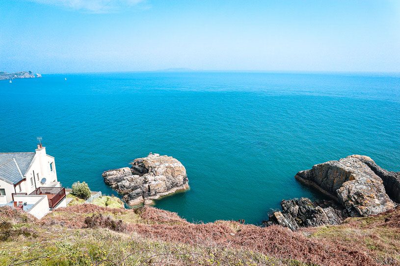 Bright blue ocean by cliffs