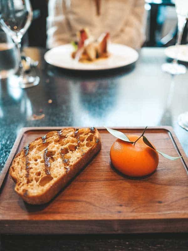 bread and a fruit on a slab of wood