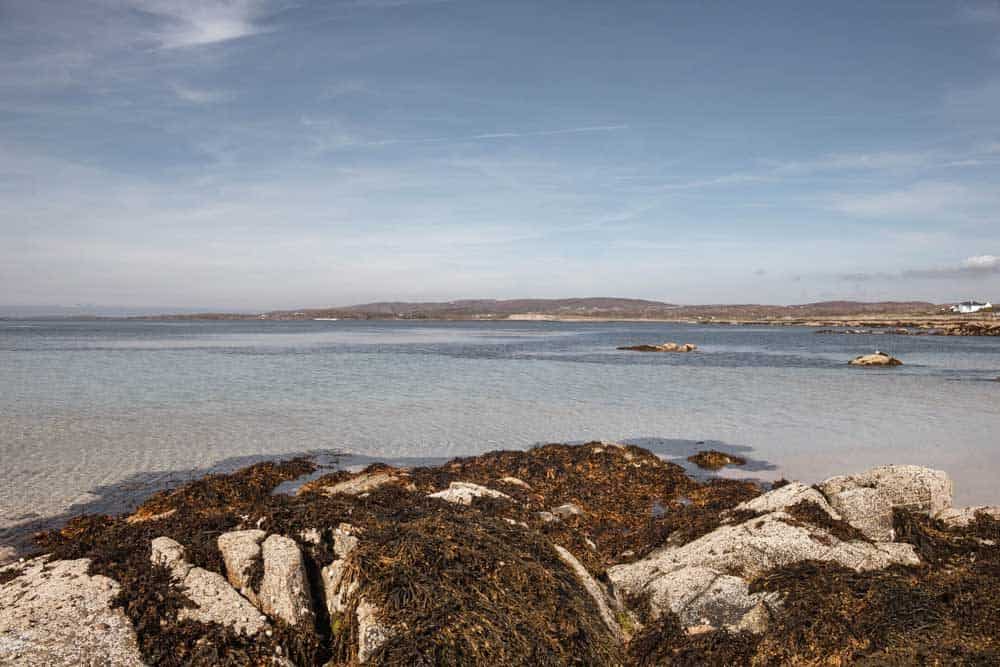 Beach with clear waters and rocks.