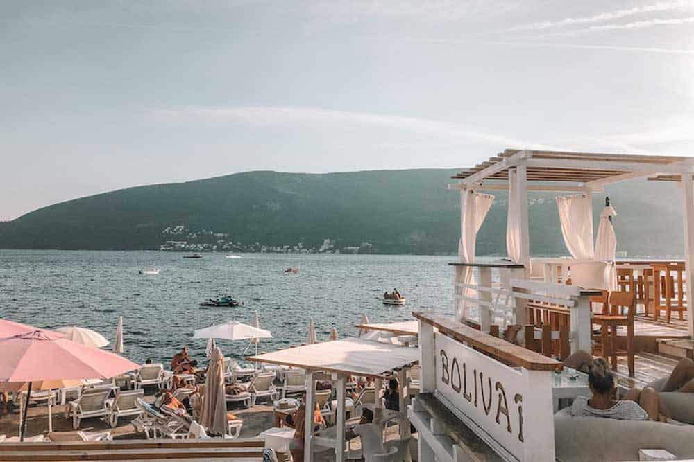 People sitting on a deck by the water in Montenegro