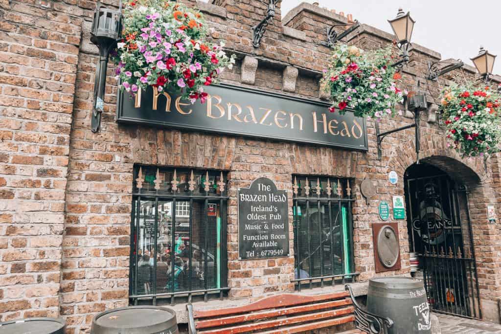 Front of an old stone building with a sign on it that says "The Brazen Head" 