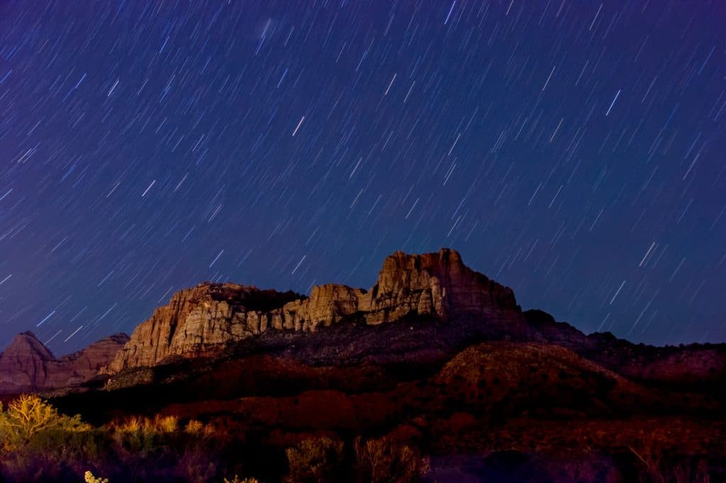 Stars in the dark night sky over a mountain 