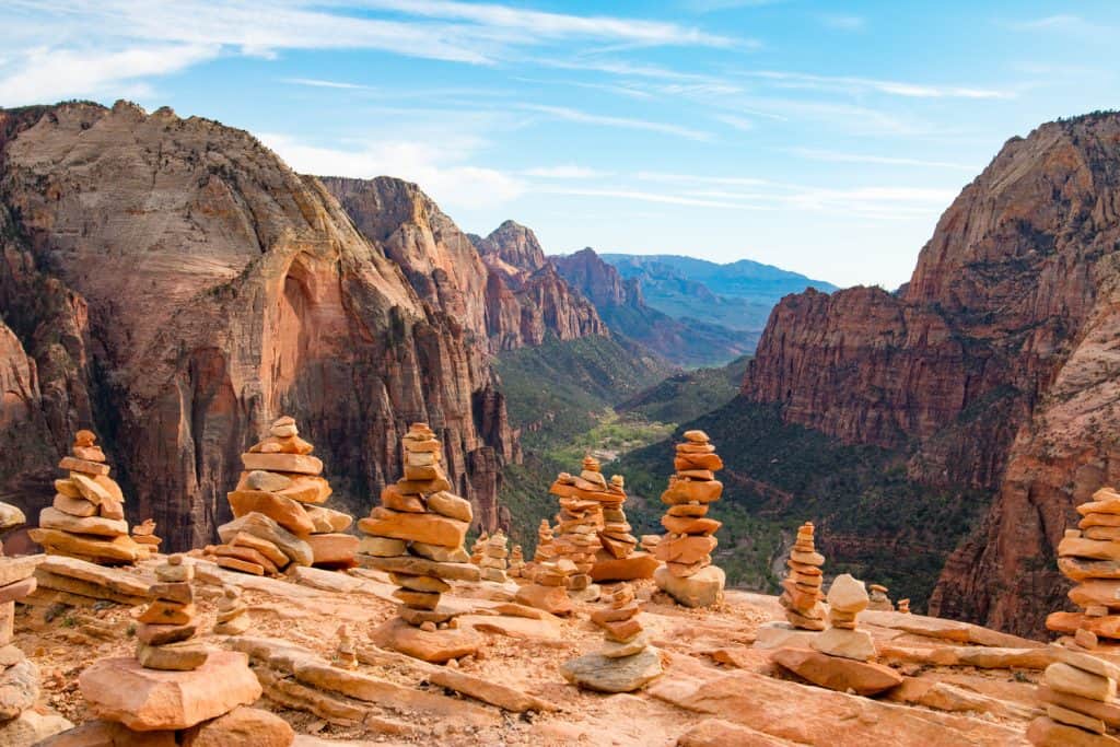 Rock cairns standing tall on top of a mountain near a canyon