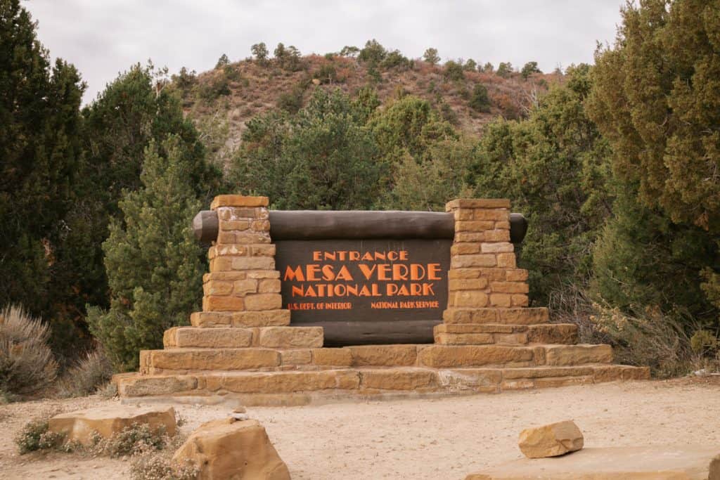 entrance sign to Mesa Verde National Park with two stone pillars on either side 