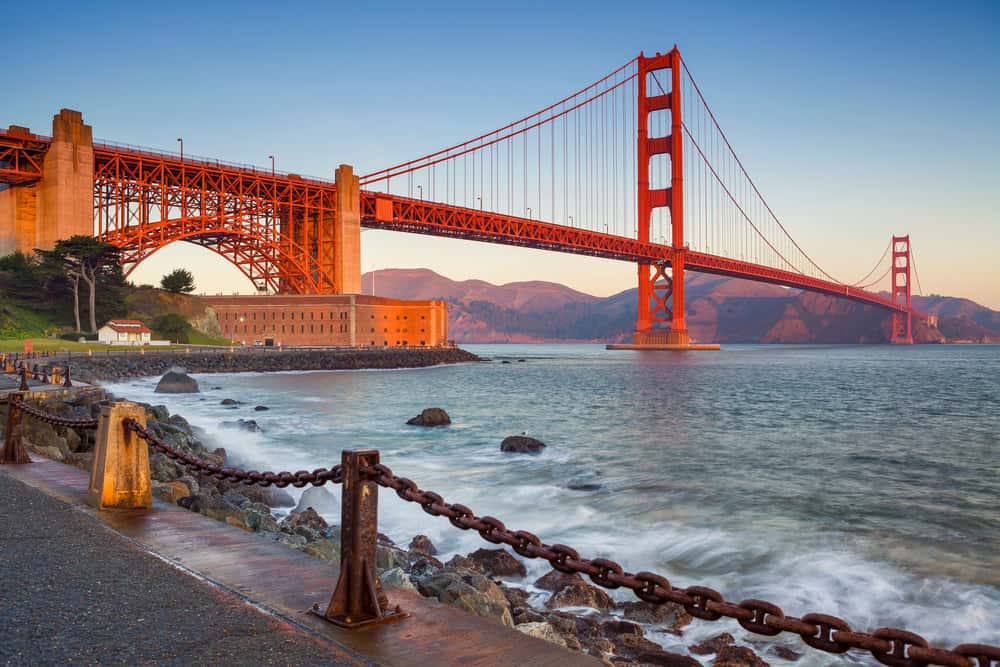 Red bridge stretching over the water at sunset.