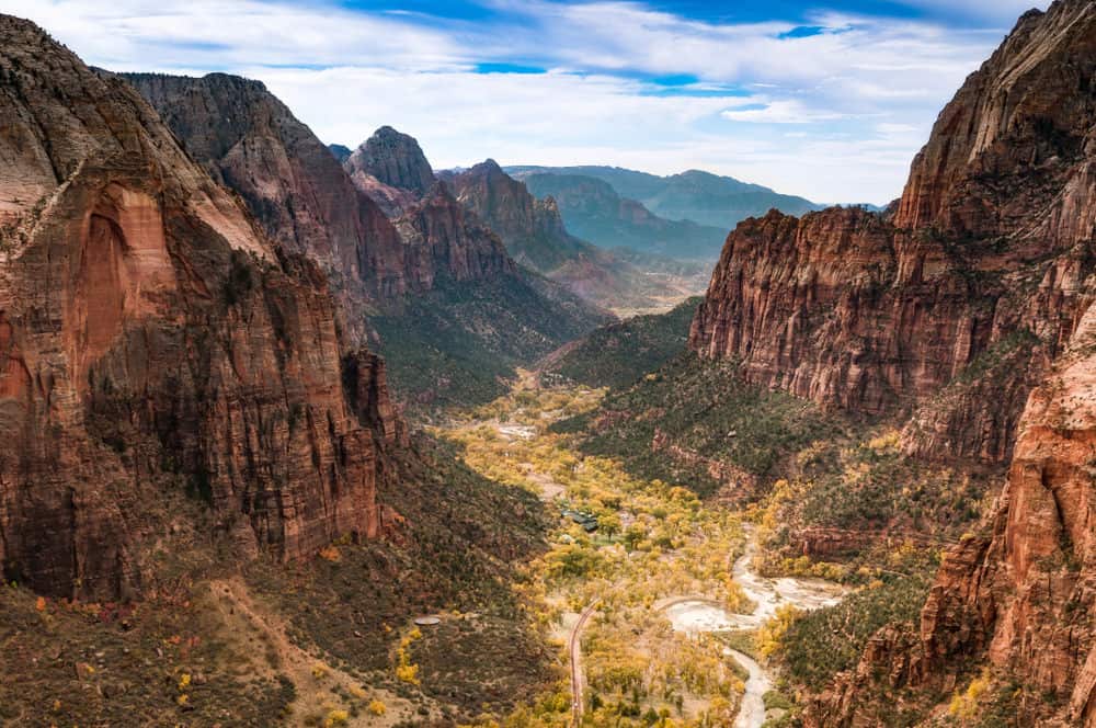 View of a canyon surrounded by tall mountains with a river running through it.