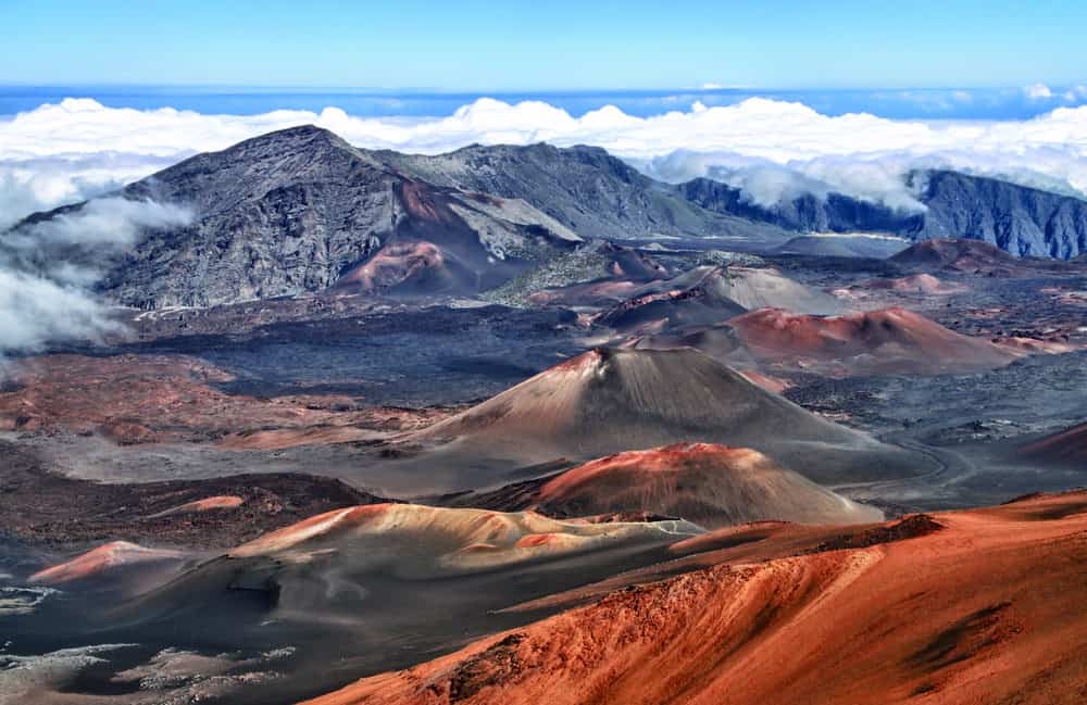 A landscape featuring mountains with orange and blue colors up in the clouds.