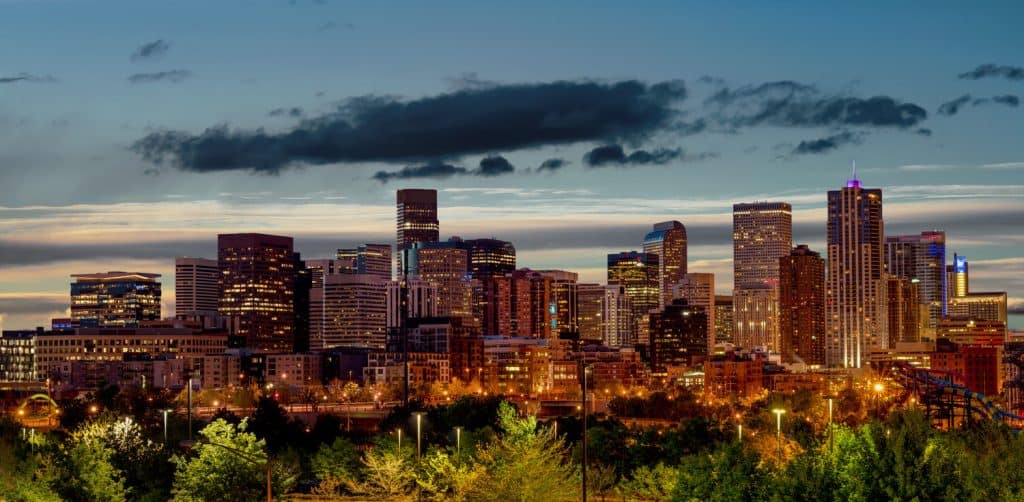 City skyline lit up at night under a dark blue sky.