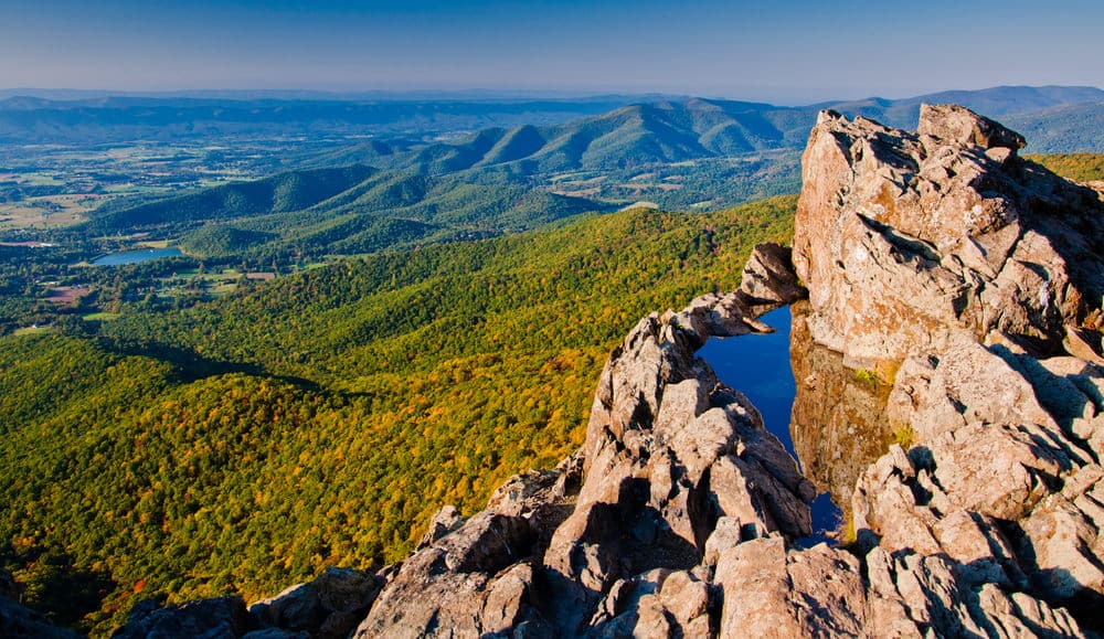 In the foreground, there's a rock piece covered in water. The distance shows mountains.