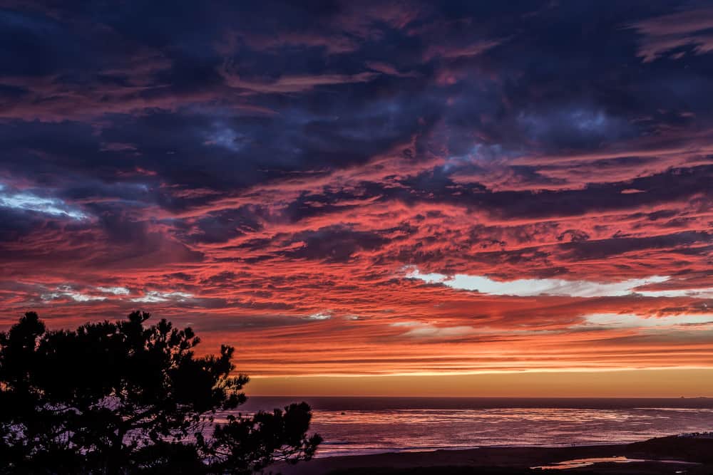 orange, red, and blue clouds at sunset over the ocean