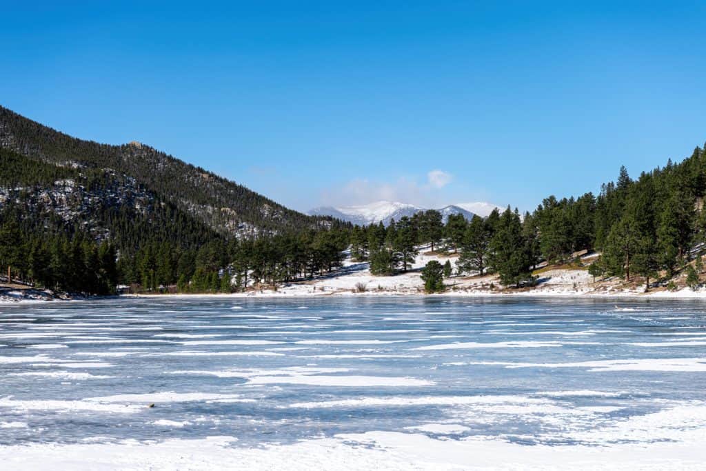 Icy lake next to mountains.