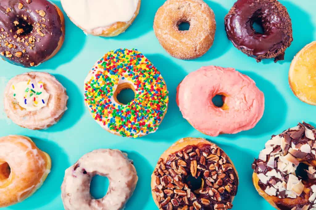 View of a bunch of donuts on a blue table.