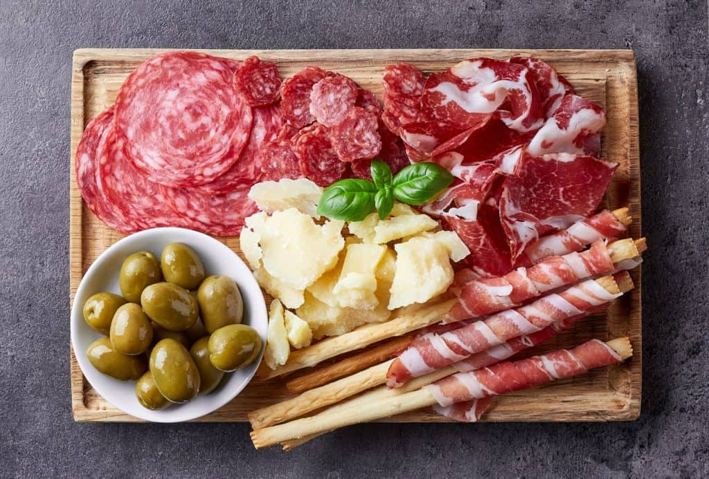 Charcuterie board with meat, cheese, and olives.