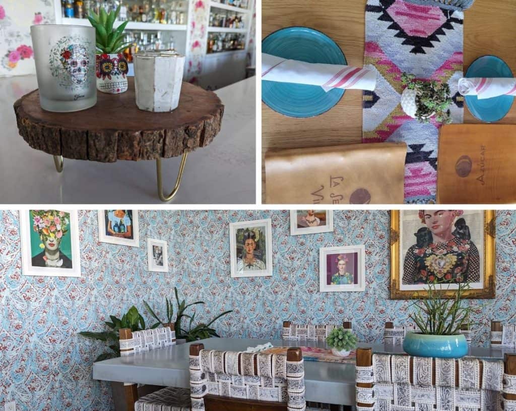 A large rectangular table with small decoration on it and patterned wall paper on the wall behind.
