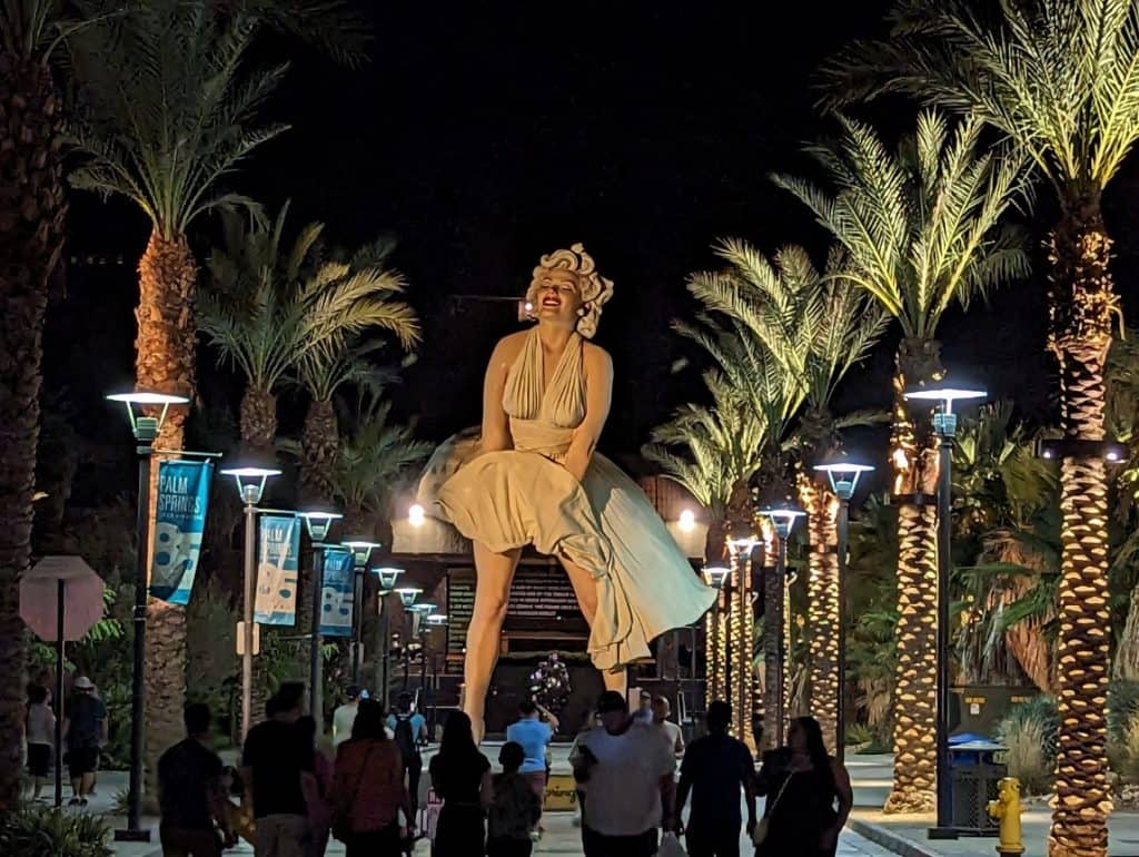 A crowd of people standing in front of the iconic Marilyn Monroe statue in Palm Springs