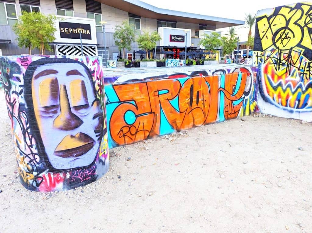 A sandy area with walls covered in graffiti.