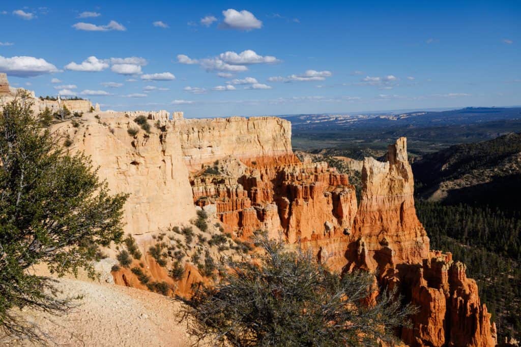 Hoodoos with rolling green mountains in the background.