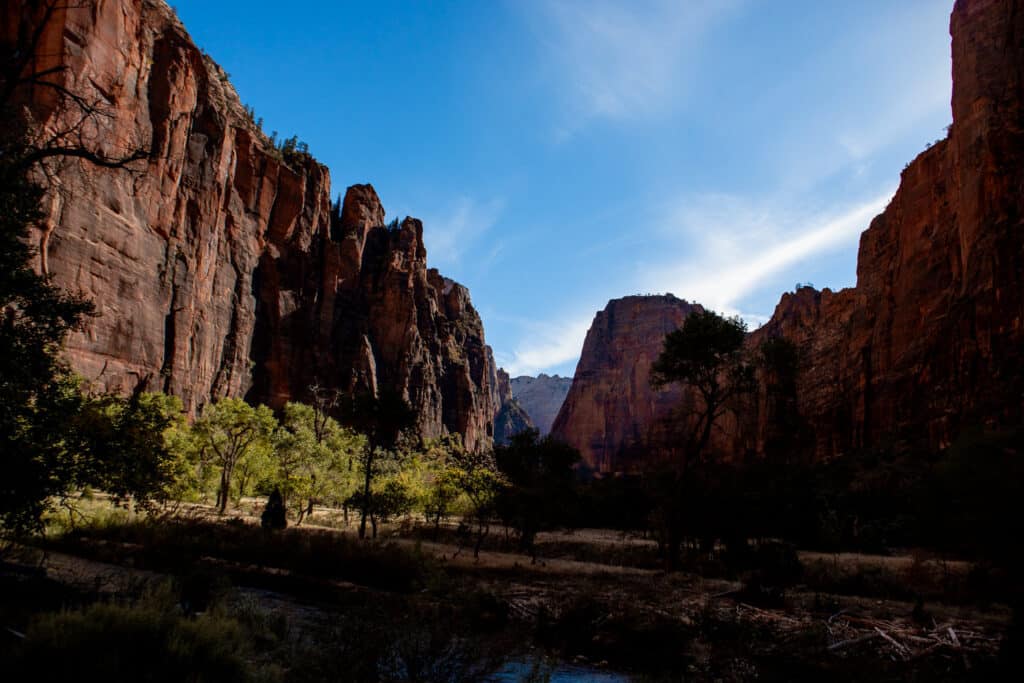 Tall cliffs shadowed with bright blue sky above