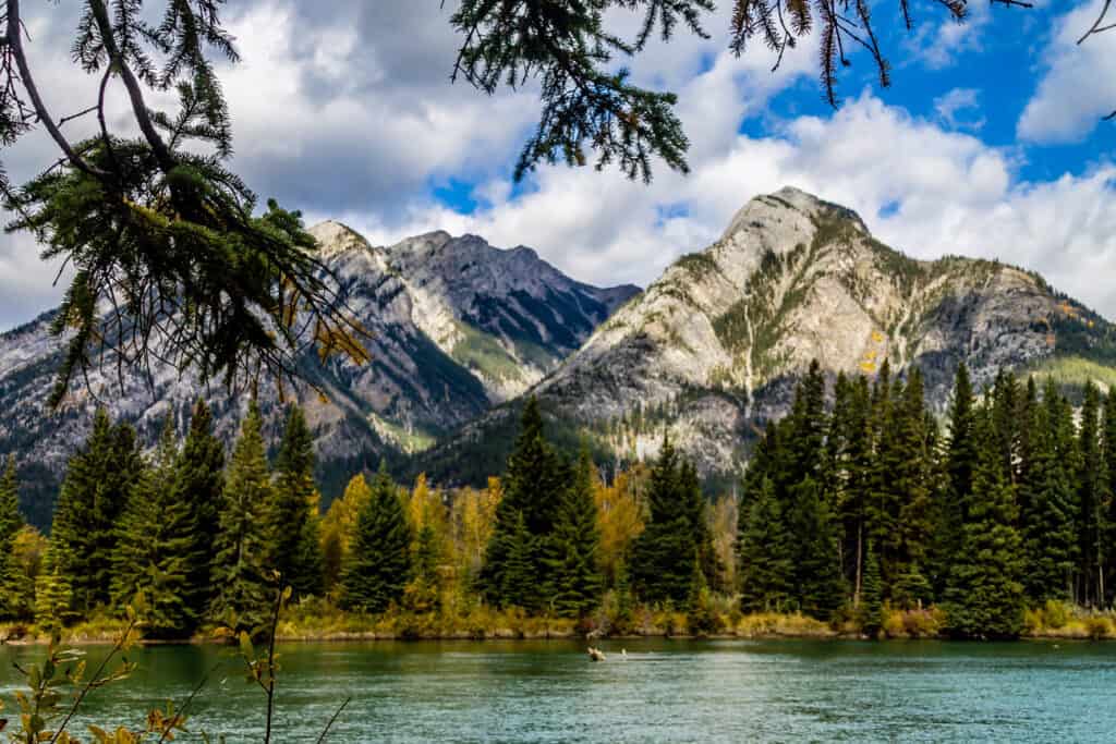 Rocky mountains surrounded by trees and blue-green water