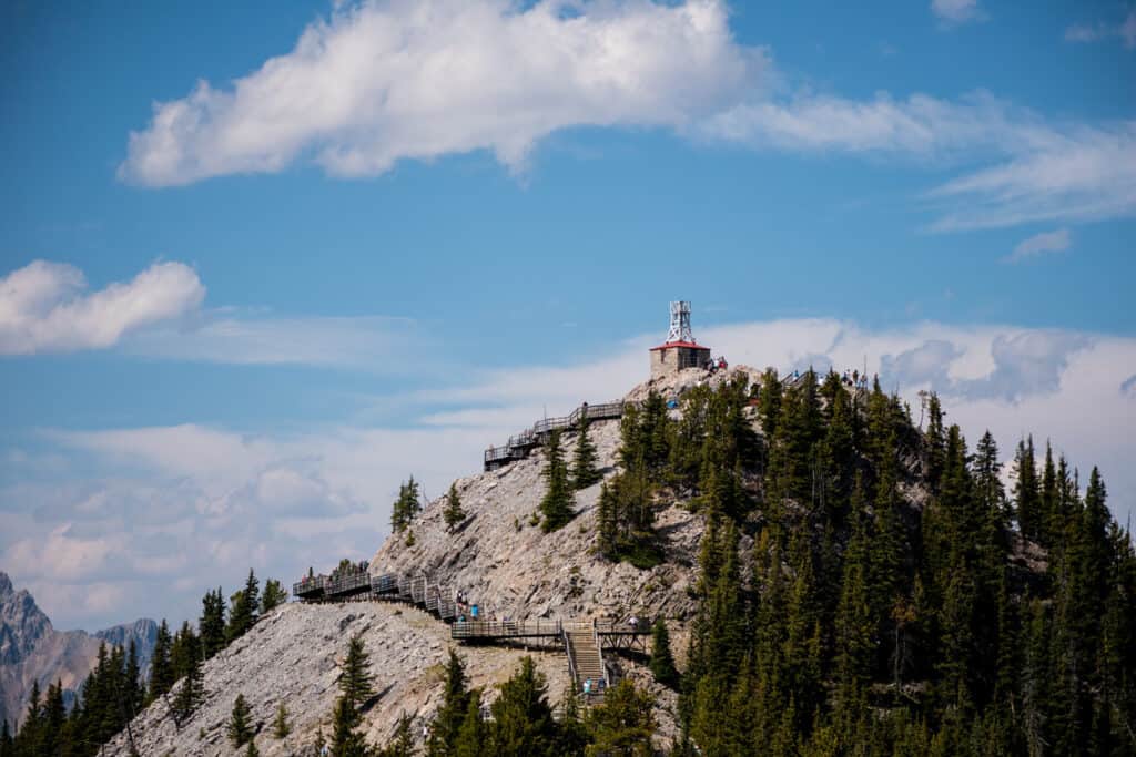 Wooden stairs leading up mountaintop with blue sky in background