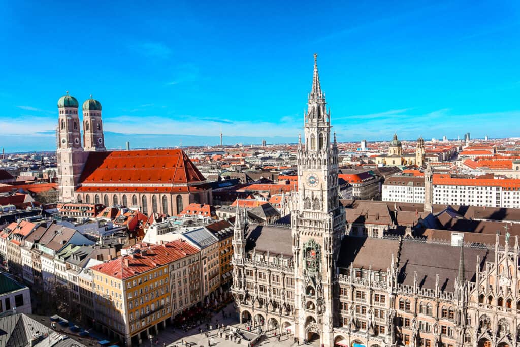 Another high-angle view of the New Town Hall in Munich, with the cityscape stretching into the distance, showing a mix of modern and traditional buildings under a blue sky.