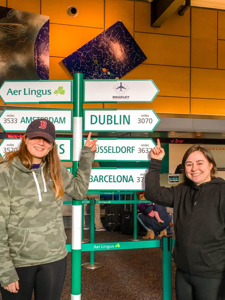Two girls pointing at signs in Bradley International Airport.